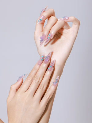 Hand wearing Star of the Tide long almond nude jelly press-on nails with turquoise gem accents
