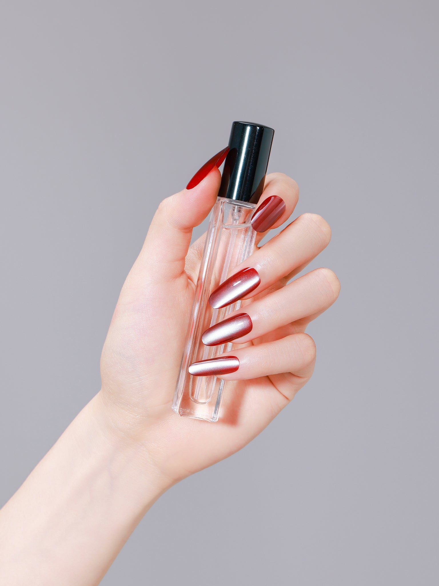 Hand wearing Red Velvet deep red long oval press on nails for everyday manicure