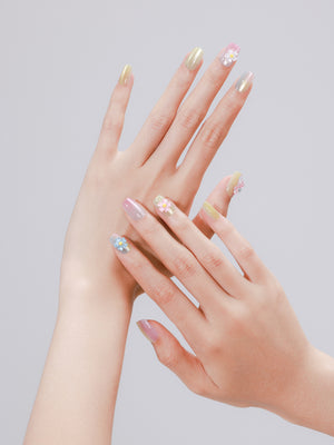 Hand wearing Candy Pop pastel dragonfly and daisy square press on nails for cute spring manicure