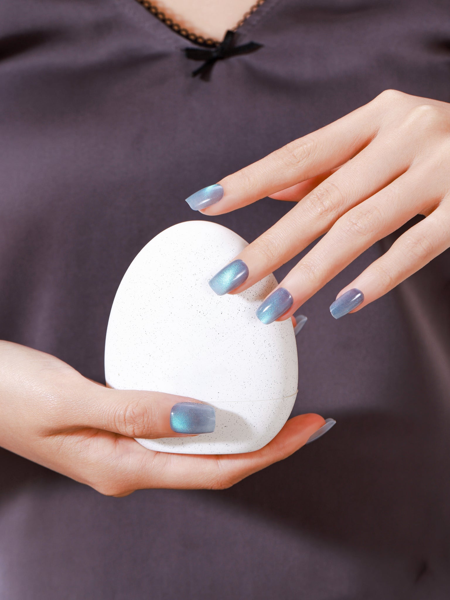 Set of light blue cat-eye nail polish on a white background