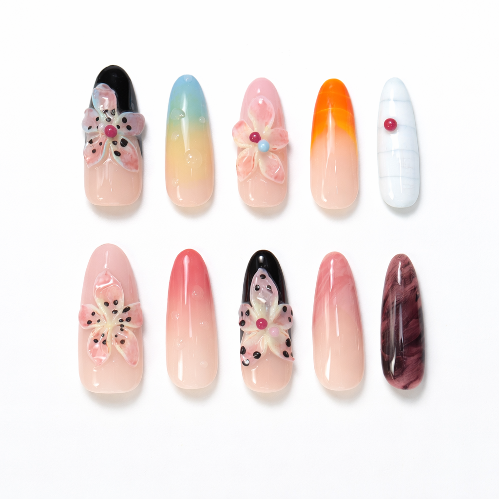 Long almond press on nails set with 3D pink flower accents, pastel gradient nails, orange French tips and glossy gel finish

