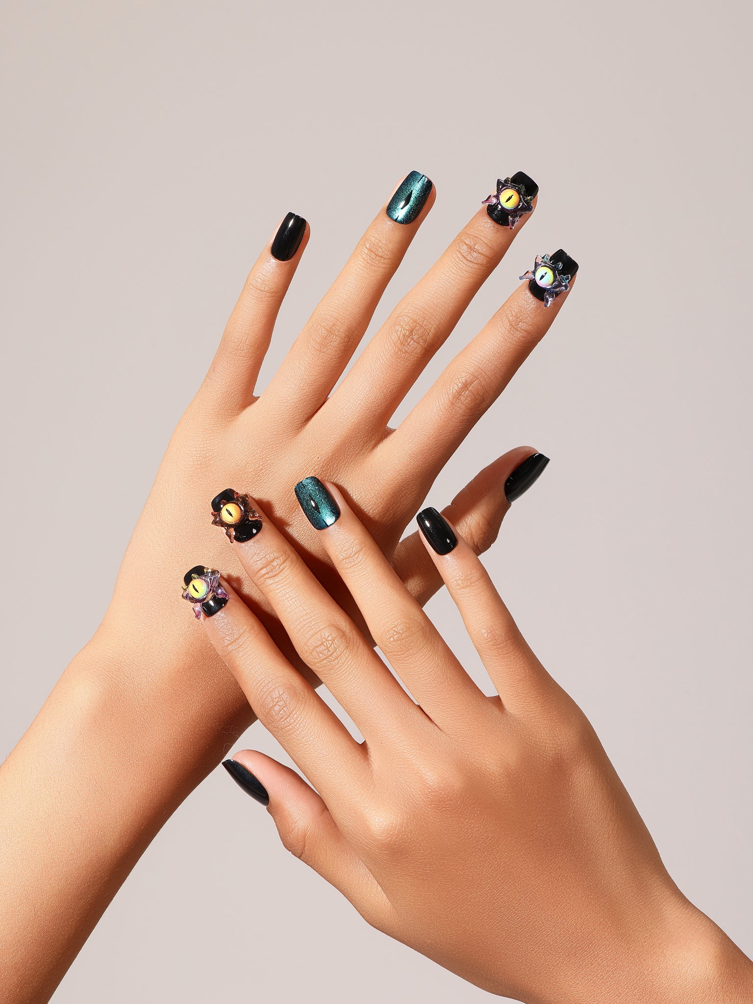 Flat lay Night Watcher press-on nails black and teal cat eye set with 3D charm accent nails