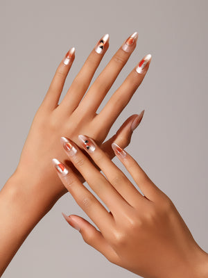 Hand wearing Love Dip champagne heart almond press on nails for romantic date night look