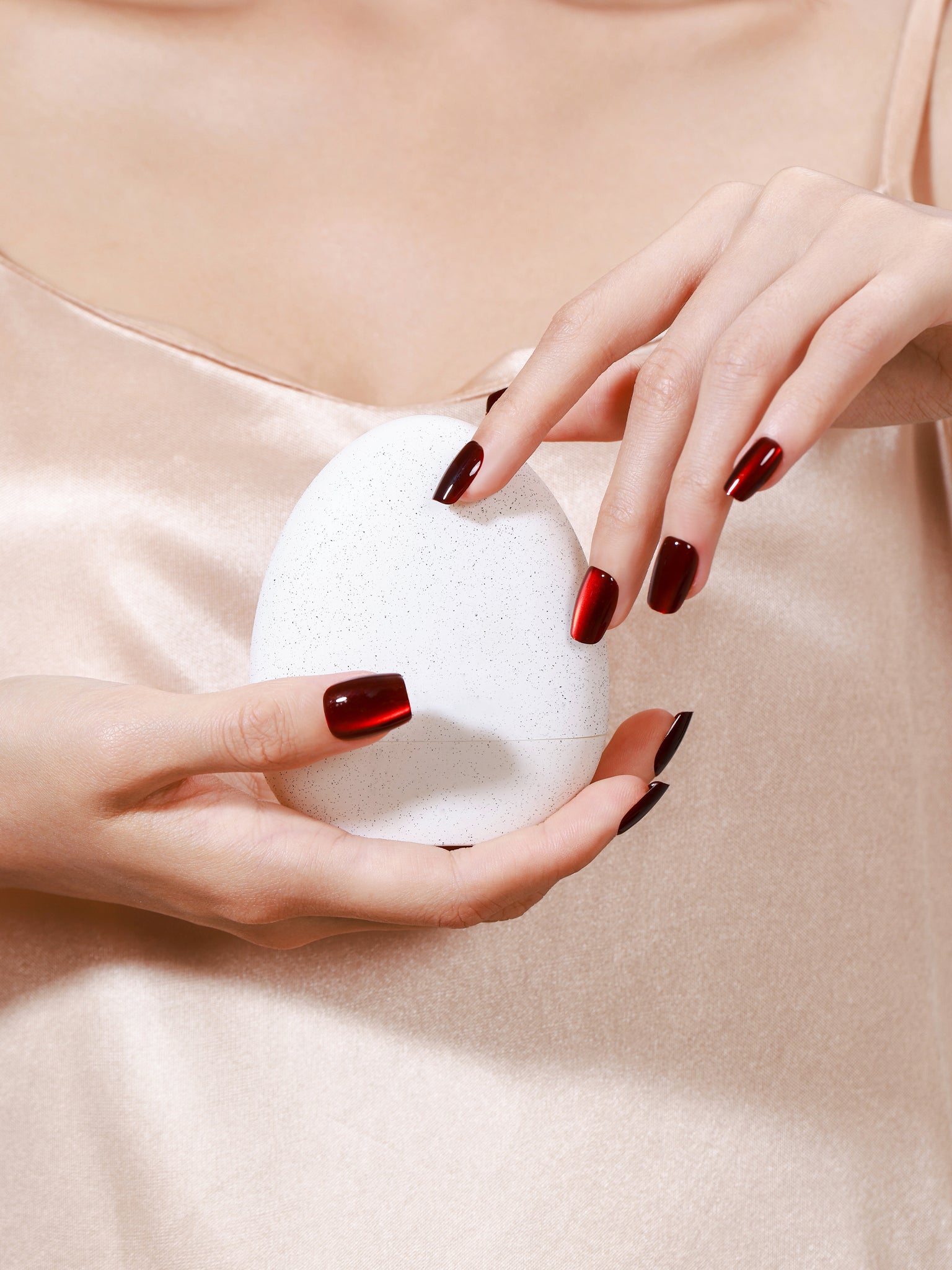 Hand wearing Cherry Flame red cat eye square press on nails for bold night out look