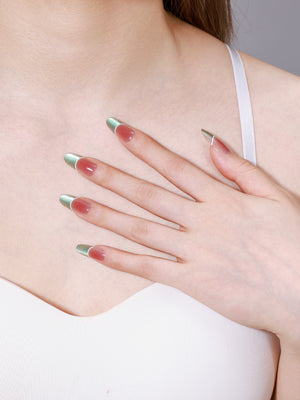 Close-up of Fresh Meadow long oval mint green French tip press-on nails on peach base