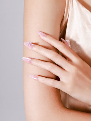 Close-up Silk Butterfly blush pink chrome press-on nails glossy pearl shine with floral charm detail