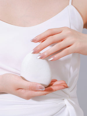 Hand wearing Latte Dust long oval latte nude press-on nails with glossy gel finish