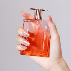 Pawfectly Peachy medium square peach press-on nails with pink paw nail art holding orange perfume bottle