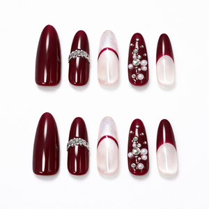 Burgundy French press on nails almond shape with nude ombre base, crystal rhinestones, and pearl accents shown as a 10 piece handmade set
