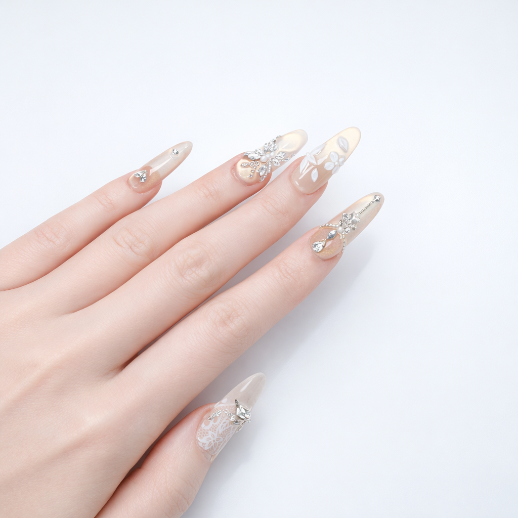Luxury bridal style champagne nude almond press on nails with rhinestone embellishments and delicate floral nail art on a neutral glossy base
