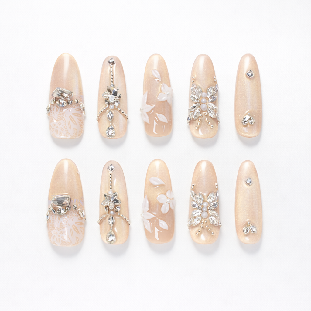 Champagne nude almond press on nails set with crystal rhinestones, 3D floral accents and glossy finish shown as a 10 piece handmade set
