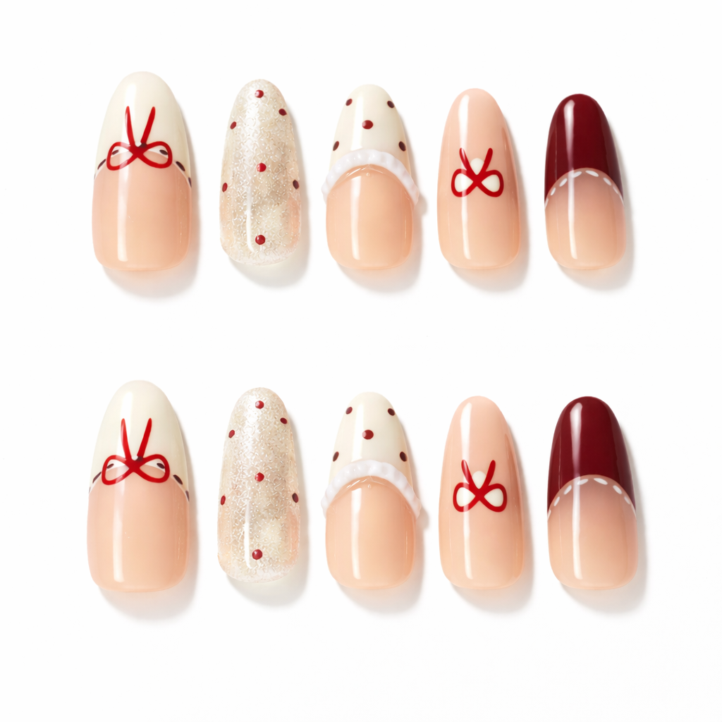Set of almond press on nails featuring nude ombre base, red bow French tips, polka dot accents and glossy gel finish
