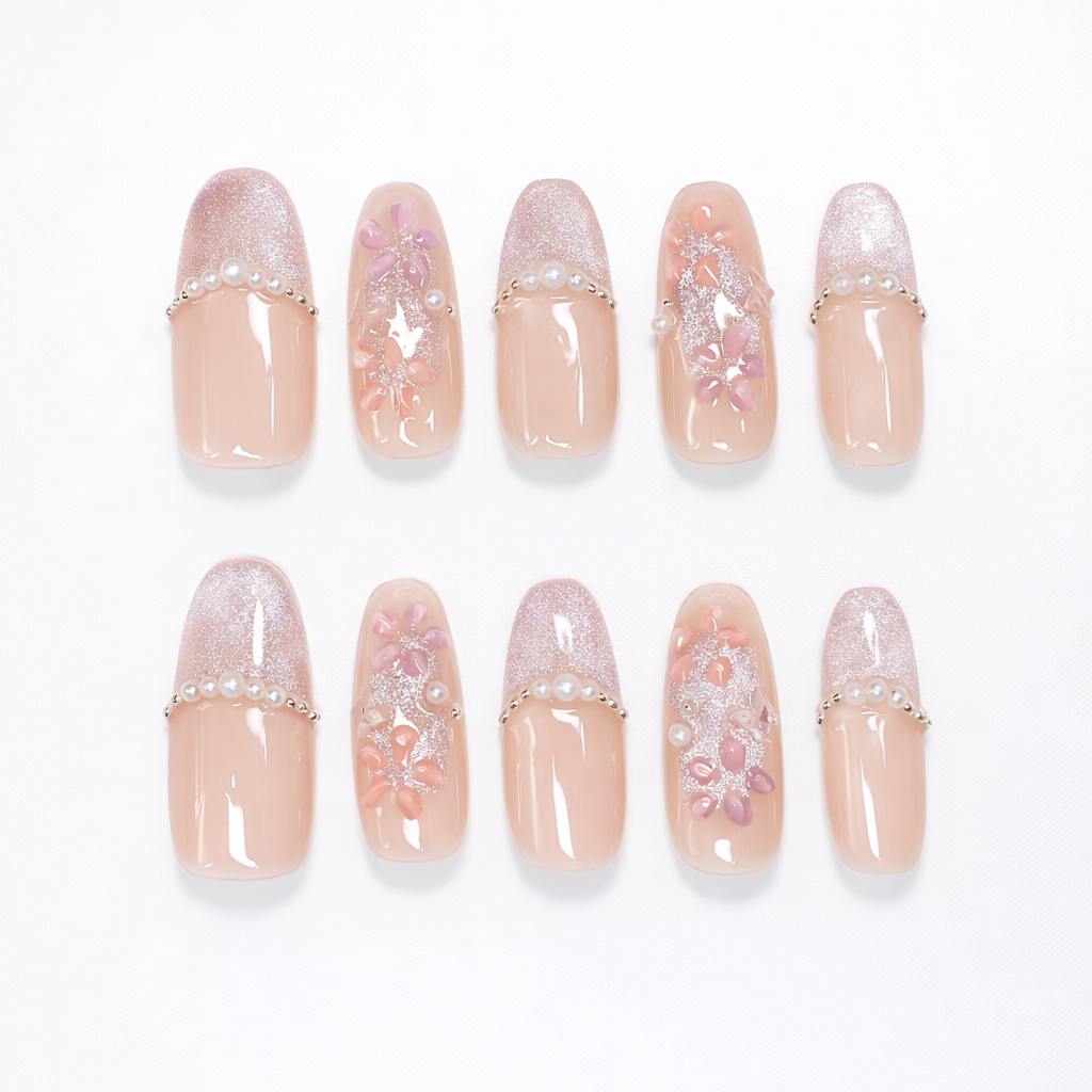 Soft blush almond press on nails with sheer nude base, pearly glitter tips, delicate pink floral accents, and micro pearl details in a full 10-nail set